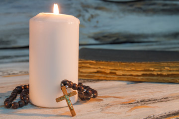 Wall Mural - Burning candle and rosary with crucifix cross. Close up. Pray and worship concept.