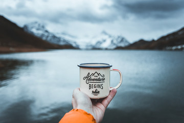 close-up of male hand holding mug. the adventure begins travel,hiking and camping concept