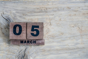 cube calendar for march on wooden background with copy space