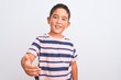 © Krakenimages.com - Beautiful kid boy wearing casual striped t-shirt standing over isolated white background smiling friendly offering handshake as greeting and welcoming. Successful business.