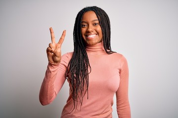 Young african american woman standing casual and cool over white isolated background showing and pointing up with fingers number two while smiling confident and happy.