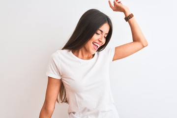 Canvas Print - Young beautiful woman wearing casual t-shirt standing over isolated white background Dancing happy and cheerful, smiling moving casual and confident listening to music
