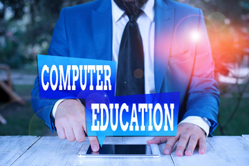 Poster - Word writing text Computer Education. Business photo showcasing gaining basic knowledge and skills to operate computers Businessman in blue suite with a tie holds lap top in hands