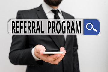Poster - Writing note showing Referral Program. Business concept for employees are rewarded for introducing suitable recruits Male human wear formal work suit hold smartphone using hand
