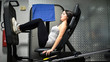 © Minerva Studio - Woman using a leg press machine in a fitness club