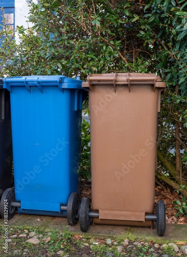 Blue and brown recycling bins in the garden
