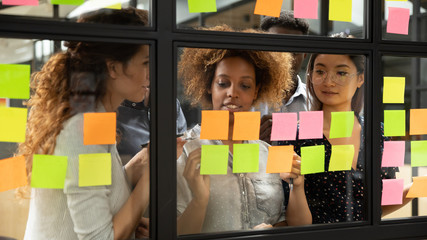 Wall Mural - focused multiethnic colleagues brainstorm using sticky notes