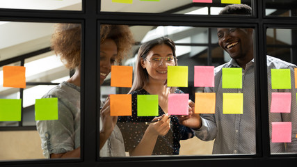 Wall Mural - multiethnic smiling team brainstorm using sticky notes