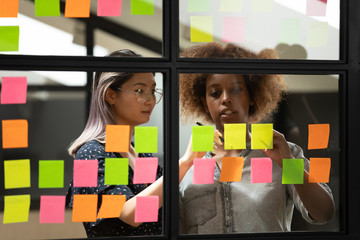 Wall Mural - multiethnic female colleagues develop business plan in office
