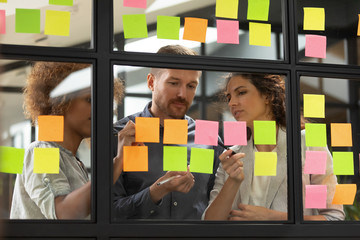 Wall Mural - multiethnic colleagues busy writing ideas on post it stickers