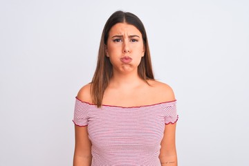 Sticker - Portrait of beautiful young woman standing over isolated white background puffing cheeks with funny face. Mouth inflated with air, crazy expression.