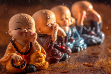 Three Baby Laughing Buddhas Sitting In The Three Monkeys Format With Another Fourth Baby Laughing Buddha Sitting In Front Of Them In A Thinking Pose