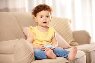 Sticker - Portrait of cute little child on sofa at home