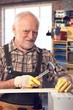 © nyul - Happy pensioner hammering at DIY home workshop