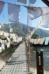 Wall Mural - Prayer flags protect suspension bridge