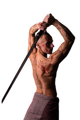 Handsome man with a bare torso and blood. Posing with a sword. Isolated on a white background.