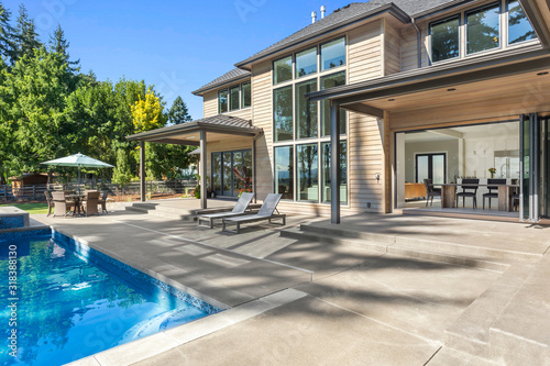 Fotomural Luxury home exterior and pool on sunny day with blue sky