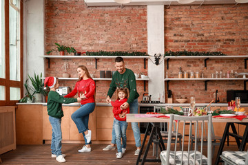 Poster - Happy family dancing on Christmas eve in kitchen