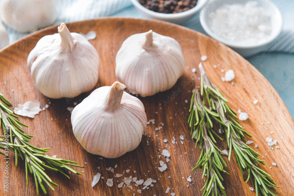 Fresh garlic with salt and herbs on plate, closeup