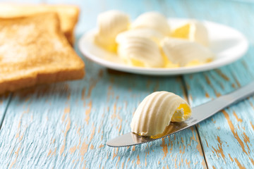 Wall Mural - Butter and  toasted bread slices  on a blue wooden table.