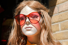 Mannequin Wearing Sunglasses Against Wall