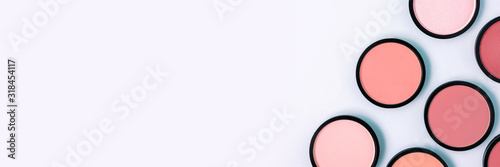 Fotografía Pink blush and compact powder on a pastel blue background