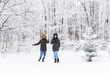 © satura_ - Fun, season and leisure concept - love couple plays winter wood on snow
