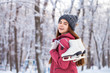 © Andrey_Arkusha - Happy beautiful brunette woman with ice skates go to the rink, winter outdoors