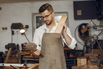 Wall Mural - Man working with a wood. Carpenter in a white shirt