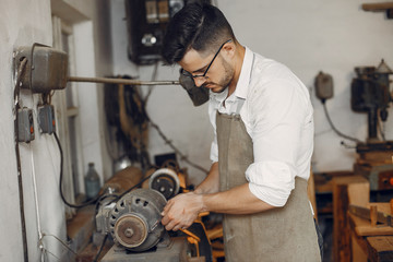 Wall Mural - Man working with a wood. Carpenter in a white shirt