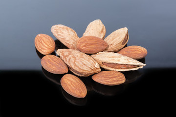 Wall Mural - Peeled and unshelled almonds on a dark reflective surface
