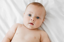 Close Up Portrait Of Serious Baby With Blue Eyes