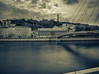 Waterfront of the Saone river in Lyon with the Basilique de Fourviere on top of the hill