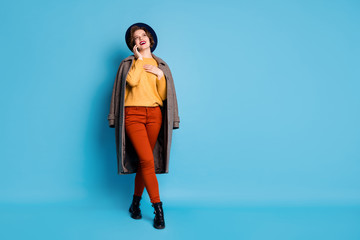 Wall Mural - Full length photo of funny lady traveler speaking telephone friends tell address shopping center wear season long grey coat sweater pants hat boots isolated blue color background