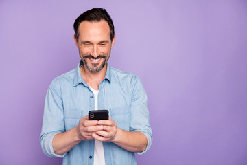 Sticker - Portrait of positive cheerful man use smart phone chatting blog post follow bloggers share social media information wear good looking clothing isolated over violet color background