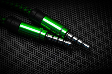 Poster - audio cable jack green. on the background of the speaker.