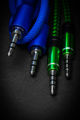 Poster - speaker cables 3.5 jack. against a dark background