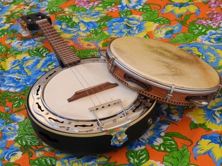 Poster - Two Brazilian musical instruments: samba banjo and pandeiro (tambourine) on a very colorful “chitao” fabric with large floral prints. They are widely used in samba and pagode ensembles.