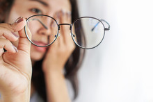 Asian Woman Hand Holding Eyeglasses Having Problem With Eye Pain, Blur Vision 