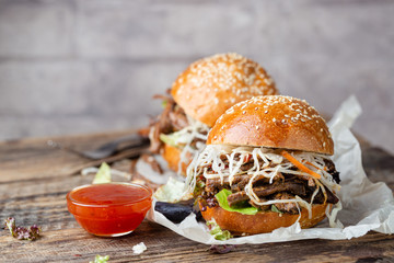 Pulled beef burger with cabbage salad and bbq sauce on paper