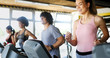 © NDABCREATIVITY - Group of people exercising in a gym cardio training and running
