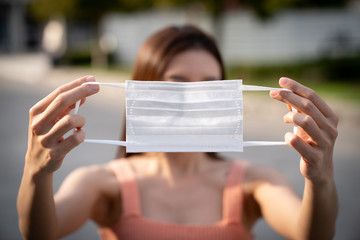 Hands holding protective medical face mask.