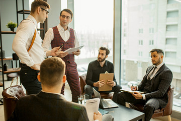 Wall Mural - caucasian business team coworking in office, everyone in formal suits, young confident leaders 25 years old gathered to discuss deadlines, business startups and ideas.