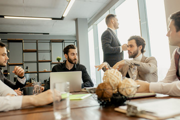 Wall Mural - young confident men developing new business startup, discussing interaction in finance and market, sharing opinions and ideas with each other, dressed in formal wear. success, business concept