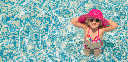 pretty little girl in swimming pool, summer vacations.