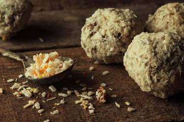 Healthy chocolate energy bites with nuts, dates, coconut flakes on a wooden table. Home made vegetarian gluten free healthy snacks. Rustic style toning.