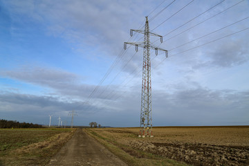 Landscape with high-voltage masts against the blue sky