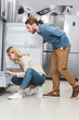 © LIGHTFIELD STUDIOS - side view of boyfriend and girlfriend looking at fridge in home appliance store