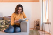 © Trendsetter Images - Woman reading book on sofa