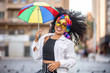 © Brastock Images - Young curly hair woman celebrating the Brazilian carnival party with Frevo umbrella on street.